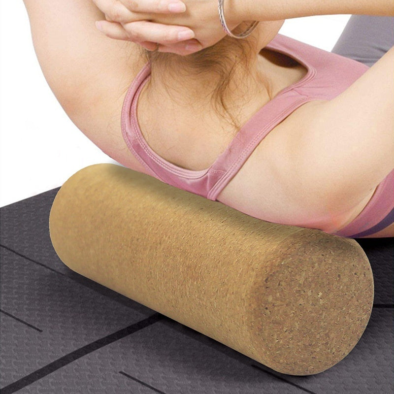 Woman lying back on a cork yoga roller placed under her upper back on a mat
