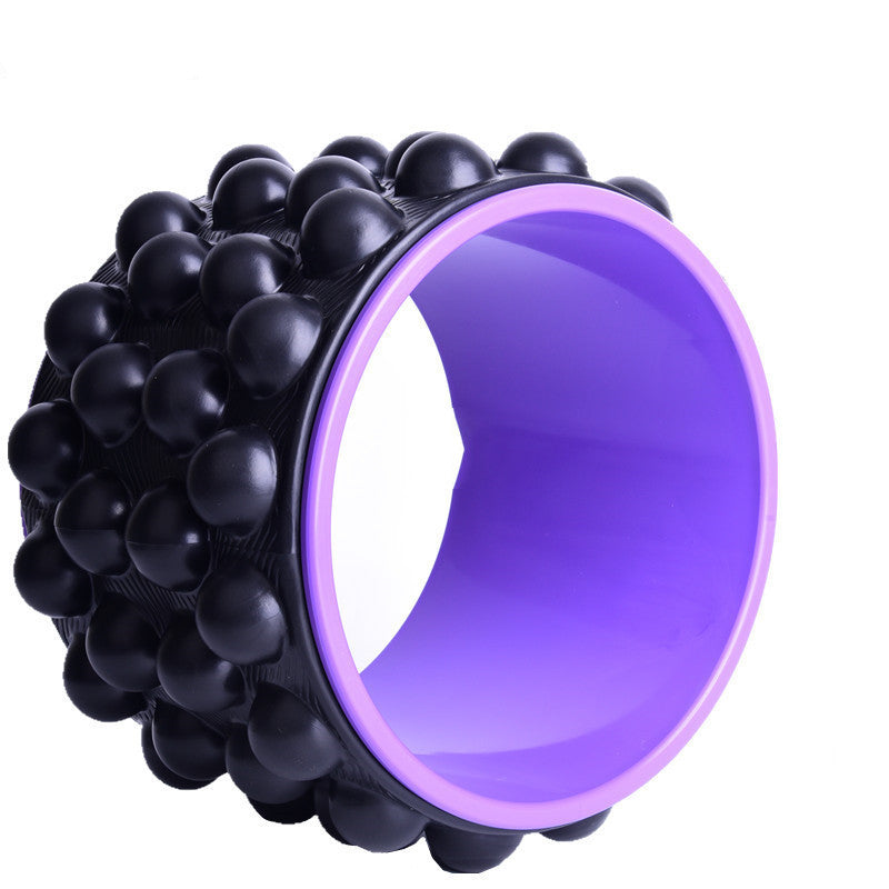 Black spiky yoga wheel with a purple inner rim