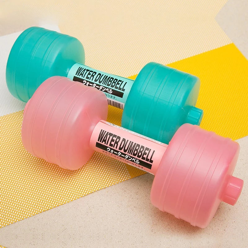Pink and teal water-fill dumbbells with labelled handles on a yellow mat