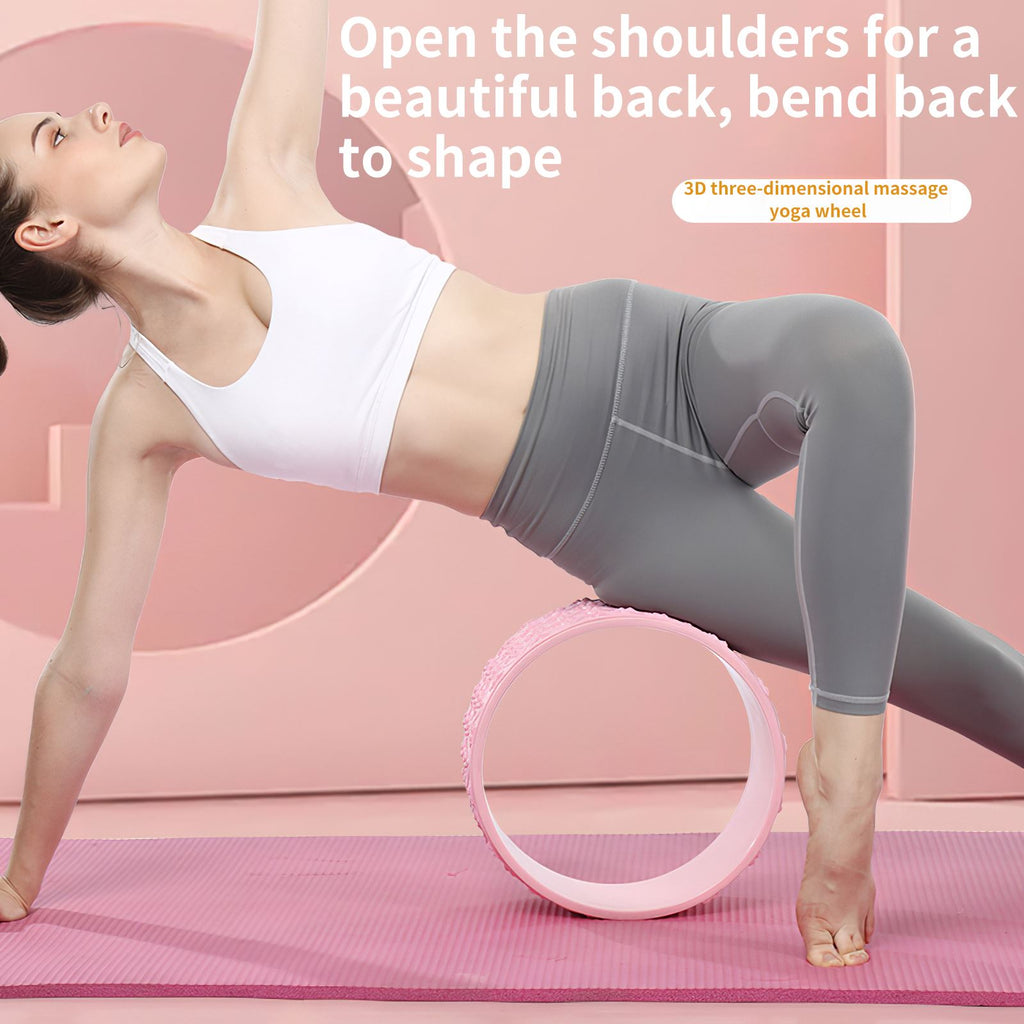 Woman in a side plank backbend over a pink yoga wheel on a mat