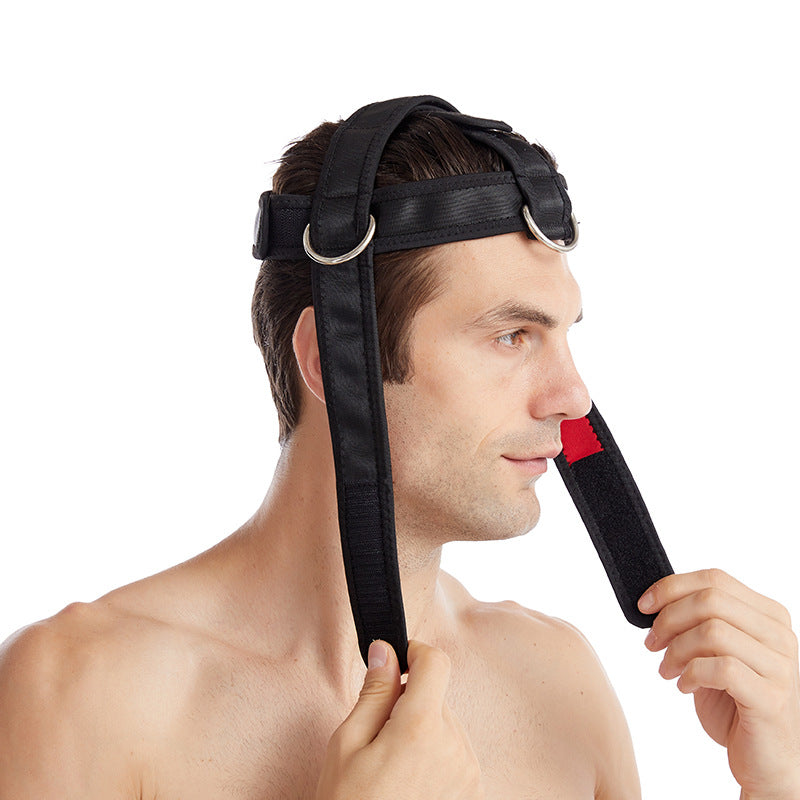 Man adjusting the chin strap of a black neck training harness