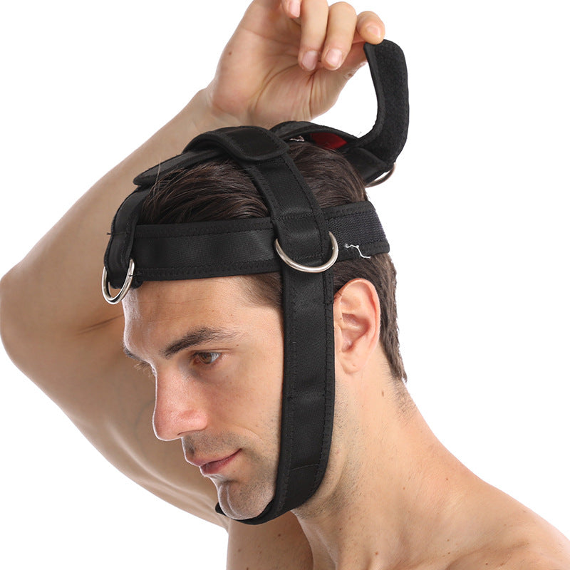 Man lifting the strap of a black padded neck training harness on his head