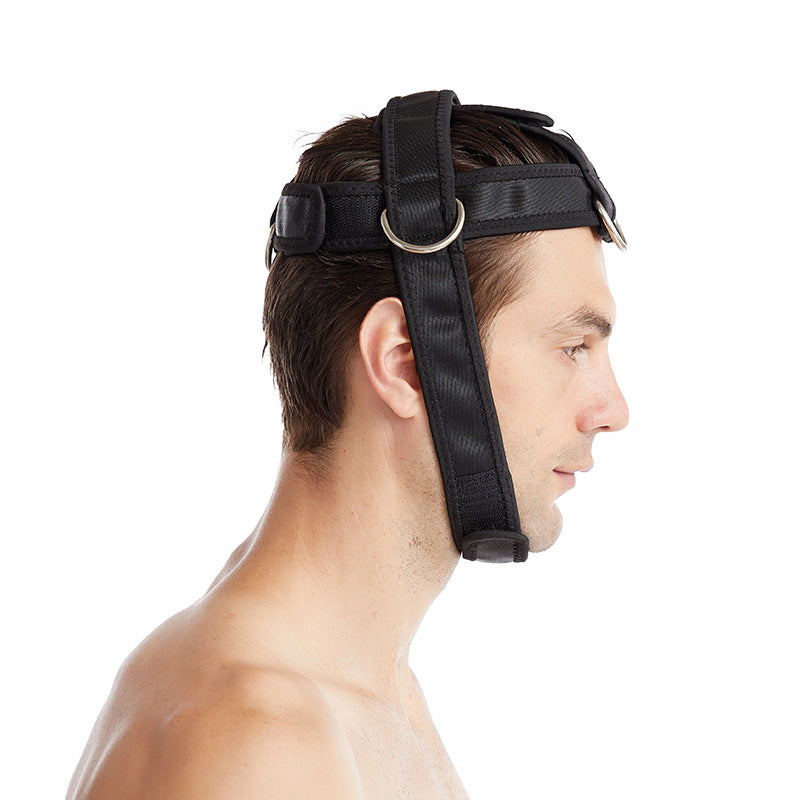 Side view of a man wearing a black neck training harness with metal D-rings
