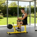 Man using a yellow seated calf raise machine with weight plates loaded, in a home gym by a window